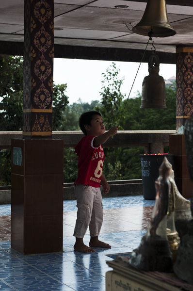 Bellboy_600px.jpg - Pikkunaskali soitti kelloja Isolla Buddhalla. Some kid plays all the bells at Big Buddha.